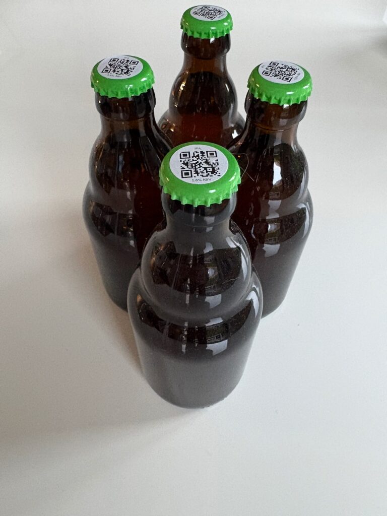 bottles of 2025 ipa with green caps and QR code